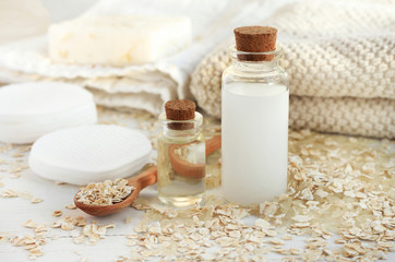 Fototapeta na wymiar Homemade skincare cosmetic. Rice water and oat flakes facial cleanser. Bottle of cereal milk, grains, towels and cotton pads. 