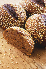 Black bread with sesame seeds on a wooden background
