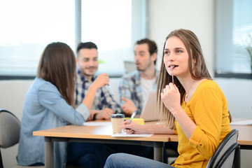 Fototapeta premium portrait of young woman in casual wear working in a creative business startup company office with coworker people in background