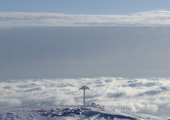 Croce isolata sulla vetta sopra le nubi