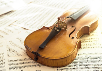 Naklejka premium Old violin lying on the sheet of music