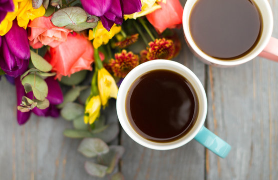 Morning Cup of coffee and a beautiful roses flowers on light background, top view. Cozy Breakfast. Flat lay style.