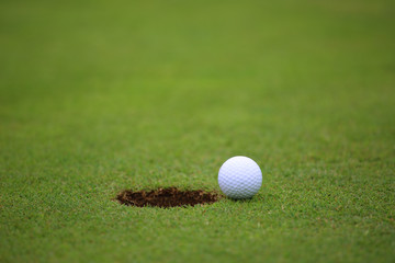 Golf ball on lip of cup