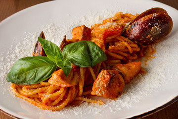 Pasta with seafood on a white plate on a wooden table