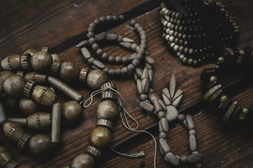 Various bracelets and beads over wooden background close up