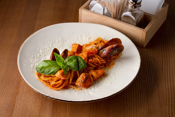 Pasta with seafood on a white plate on a wooden table