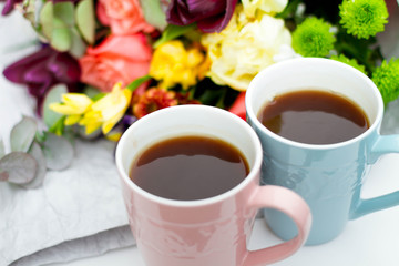 Morning Cup of coffee and a beautiful roses flowers on light background, top view. Cozy Breakfast. Flat lay style.