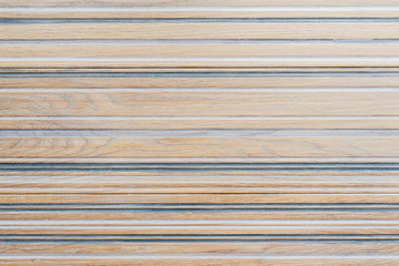 Texture of a light wooden floor with embossing and blue horizontal stained stripes. Wooden texture background.