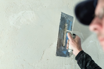 Ein Maler verputzt eine Wand