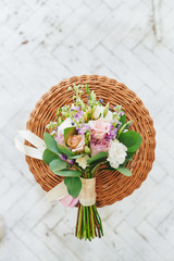 Fototapeta na wymiar Wedding bouquet flowers on braided stool top view