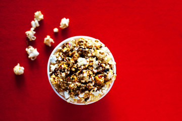 Sweet Bowl with popcorn on a red background, cinema, movies and entertainment concept.