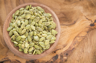 Pumpkin seeds on the wooden background