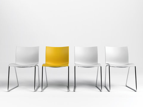 Line of three white and one yellow chairs