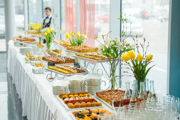 Catering. Cakes and pies on white tables