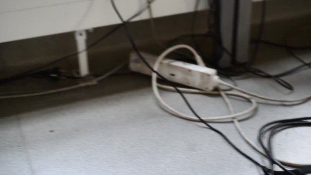 Dirty power strip plug cables raveled on a floor