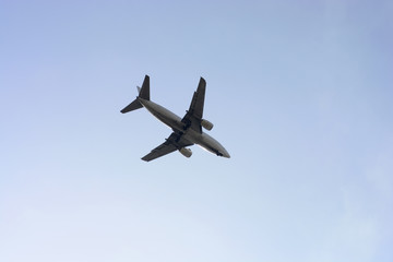 Airplane in the blue cloudless sky at sunset.