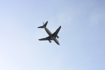 Airplane in the blue cloudless sky at sunset.