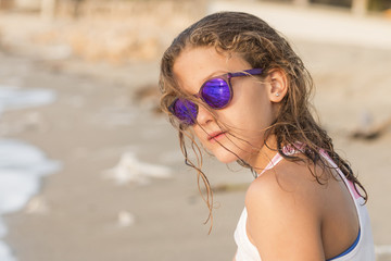 Little girl bathing on the beach with glasses.