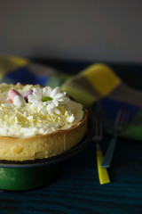 Lemon tart with whipped cream, decorated with chocolate eggs and a flower. 