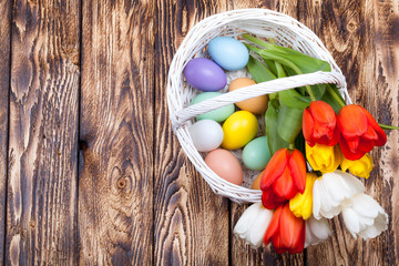 Easter Eggs in a white basket with colorful tulips