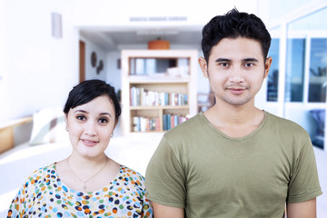 Obraz premium Happy couple looking at camera at home