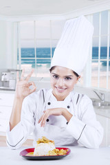 Indian chef smiling with dish on plate