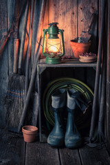 An old rustic shed with garden tools and oil lamp
