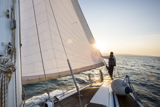 Man Standing On The Front Of Sail Boat In Sea