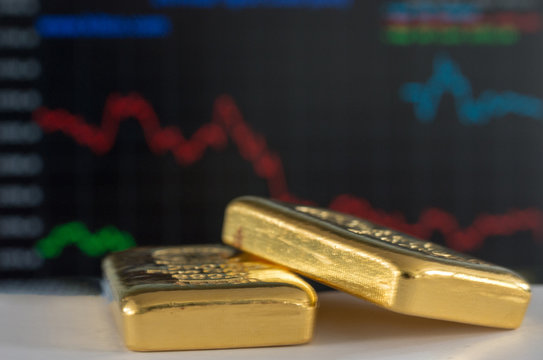 Gold bars on the background of the growth chart. Selective focus.  (shallow DOF)