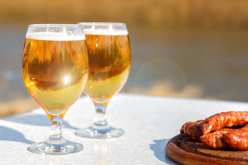 Glasses of beer and grilled sausages.
