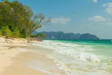 Poda island (Koh Poda) beach with trees and waves, Krabi province, Thailand