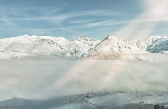 Winter ski resort covered by fog, mountain peaks in the background , Lombardy, Italy. Light leaks
