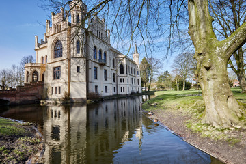Fototapeta na wymiar Die Evenburg in der Kleinstadt Leer in Ostfriesland, eine Burg mit Parkanlage, die Burg hat rundherum einen Burggraben.