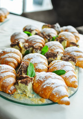 Assortment of fresh pastry on table in buffet. Croissants and cakes