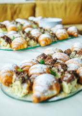Assortment of fresh pastry on table in buffet. Croissants and cakes