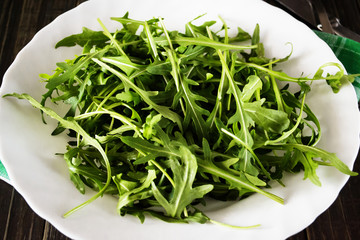 Fresh juicy arugula on a white plate