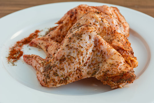 Raw chicken wings with spices ready for cooking.