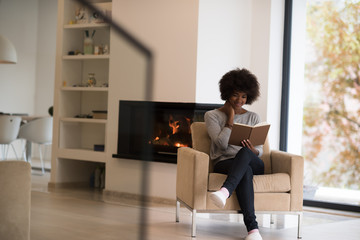 black woman at home reading book