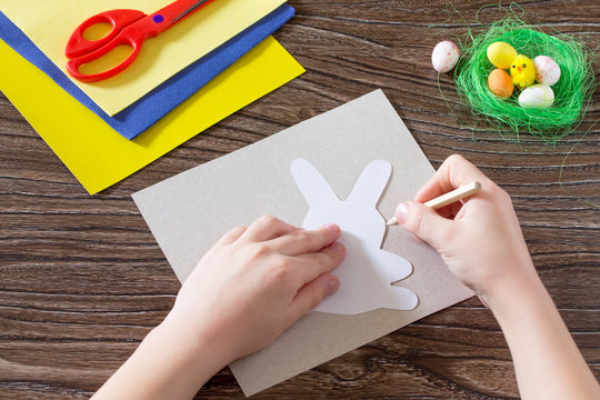Child draws items crafts. Create Easter baby gift napkin holder paper easter bunny. Made by hand. Children's Art Project, needlework, crafts for children.