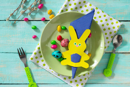 Easter decorations children stol.Stol decorating Easter bunny holding a napkin, candy and eggs. Children's Art Project, needlework, crafts for children.