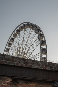 Ferris wheel behind a decaying wall
