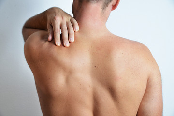 Concept of a pain in back shoulder of adult man, isolated on the white background