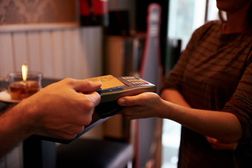 Credit card held above card machine