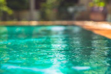 Summer holidays blurred background with swimming pool with turquoise water 