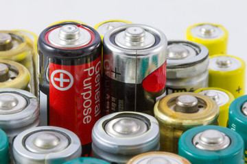 Alkaline batteries with selective focus on two red-black protruding batteries