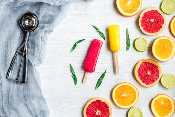 citrus slices with fruit popsicles on table background top view