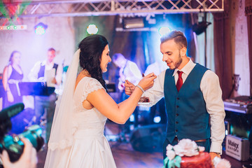 The bride and groom cut and eat the wedding cake