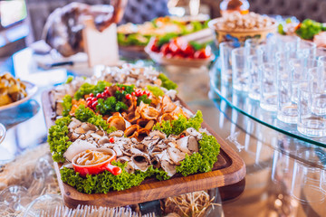 Buffet table of reception with cold snacks, meat and ham
