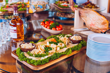 Buffet table of reception with cold snacks, meat and ham