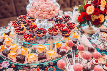 Delicious sweets on candy buffet. Lot of colorful desserts on table.